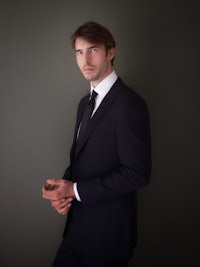 a young man in a suit posing for a photo